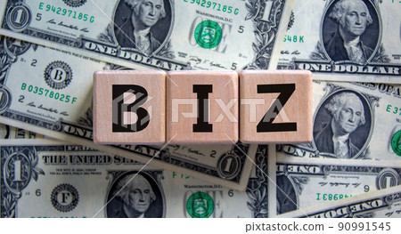 Concept word 'biz' on cubes on a beautiful background from dollar bills. Business and biz concept. 90991545