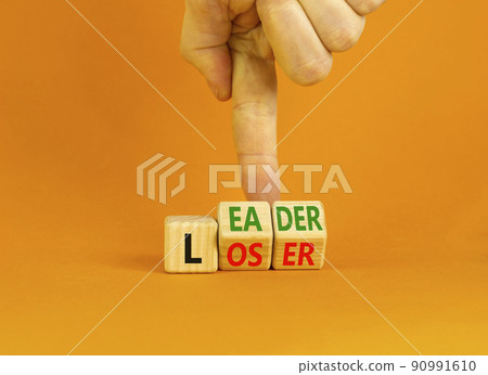 Loser or leader symbol. Concept words Loser or leader on wooden cubes. Businessman hand. Beautiful orange table orange background. Business and loser or leader concept. Copy space. Loser or leader symbol. Concept words Loser or leader on wooden cubes. Businessman hand. Beautiful orange table orange background. Business and loser or leader concept. Copy space. 90991610
