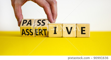 Passive or assertive symbol. Businessman turns wooden cubes and changes the word passive to assertive. Beautiful white background, copy space. Business, psychological passive assertive concept. 90991636