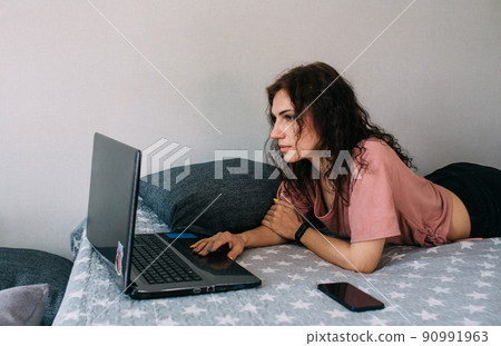 Woman working with laptop and lying on couch. Freelancing and work from home. Woman working with laptop and lying on couch. Freelancing and work from home. 90991963
