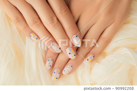 Womans hands with trendy polka dot summer manicure Womans hands with trendy polka dot summer manicure 90992208