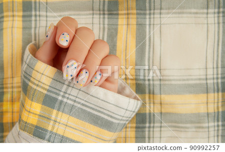 Womans hand with trendy polka dot summer manicure Womans hand with trendy polka dot summer manicure 90992257