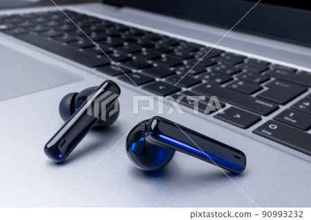 Black wireless headphones over laptop Black wireless headphones over laptop 90993232