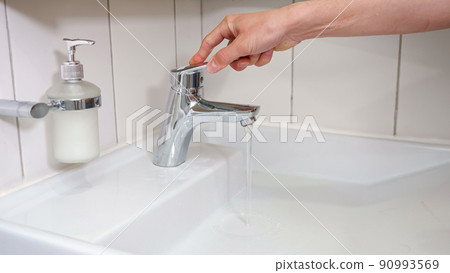 Male hands turn on tap water and wash hands with soap Male hands turn on tap water and wash hands with soap 90993569