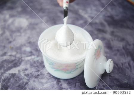 white sugar and spoon in a container on black background, white sugar and spoon in a container on black background, 90993582