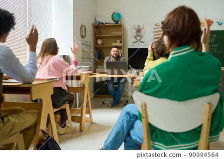 Confident mature teacher of anatomy asking questions to highschool students Confident mature teacher of anatomy asking questions to highschool students 90994564