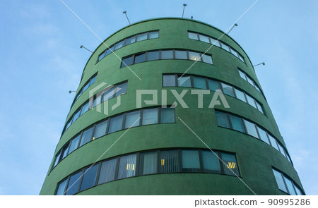Green office building in the constructivist style against the blue sky on one of the Uli in Moscow. 90995286