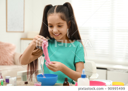 Cute little girl making DIY slime toy at table indoors Cute little girl making DIY slime toy at table indoors 90995499