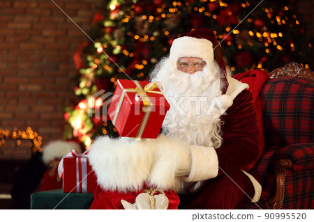 Santa Claus with gift sack near Christmas tree indoors 90995520