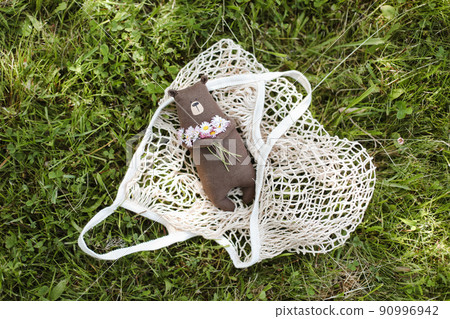 Eco-friendly cute handmade toy bear on grass at sunny summer day. 90996942