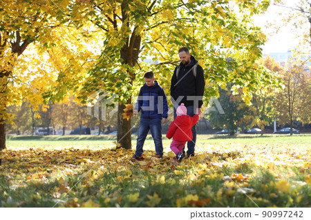 Happy father playing with his children outside in the park Happy father playing with his children outside in the park 90997242
