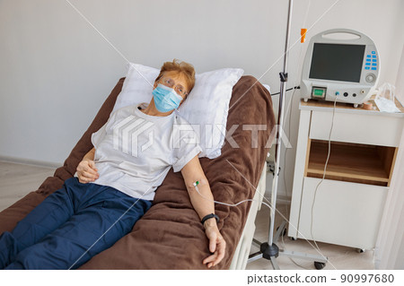 Sick patient in mask lying in hospital ward during medical procedure in clinic 90997680