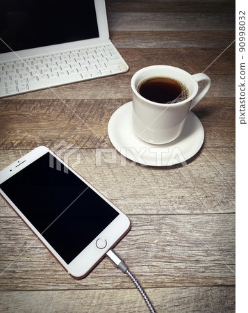 古色古香的茶歇,充電時的智能手機,垂直位置 古色古香的茶歇,充電時的智能手機,垂直位置 90998032