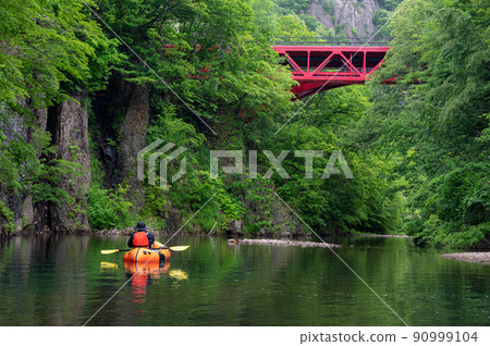 River rafting down a quiet mountain stream in Packraft 90999104