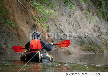 River rafting down a quiet mountain stream in Packraft 90999105