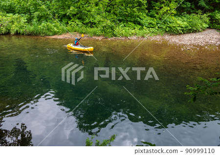River rafting down a quiet mountain stream in Packraft 90999110