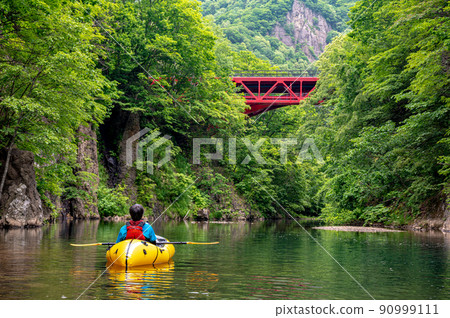 River rafting down a quiet mountain stream in Packraft River rafting down a quiet mountain stream in Packraft 90999111
