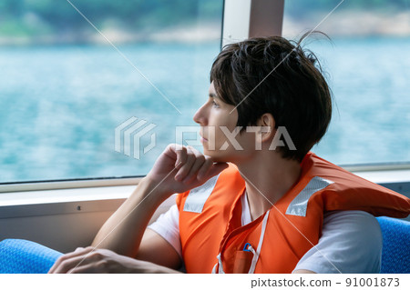 Foreign tourists on a sightseeing boat wearing life jackets 91001873