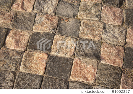 Pavement of grey and white stone plates, looks like a chess bord.the background square paving stones like chess 91002237