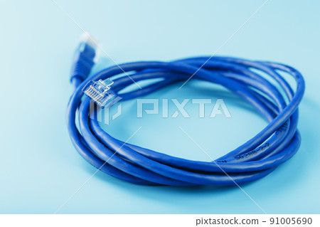 A coil of an Internet network cable for data transmission on a blue background 91005690