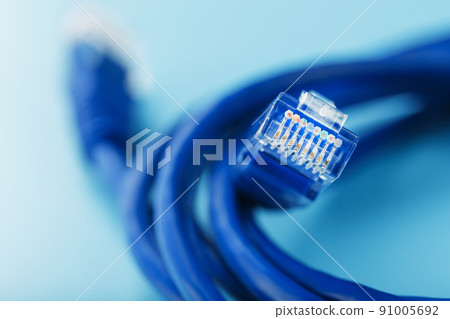 A coil of an Internet network cable for data transmission on a blue background 91005692