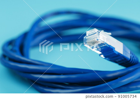 A coil of an Internet network cable for data transmission on a blue background A coil of an Internet network cable for data transmission on a blue background 91005734