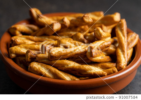 Salted pretzel sticks. Salted crackers in bowl. 91007584