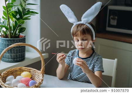 Cute little boy colouring eggs for easter 91007870