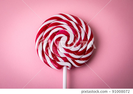 Red and white lollipop on a pink background Red and white lollipop on a pink background 91008072