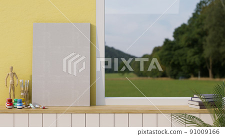 Blank empty canvas or poster mockup standing on the table against the yellow wall and window Blank empty canvas or poster mockup standing on the table against the yellow wall and window 91009166