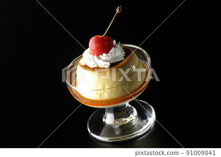黑色背景中拍攝的聖代杯上放著櫻桃和奶油的老式複古布丁 91009841