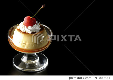 An old-fashioned retro pudding with cherries and cream on a sundae cup shot on a black background 91009844