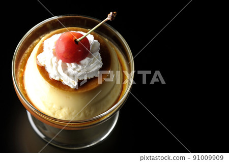 在黑色背景的聖代杯上鳥瞰老式複古布丁，配上櫻桃和奶油 91009909