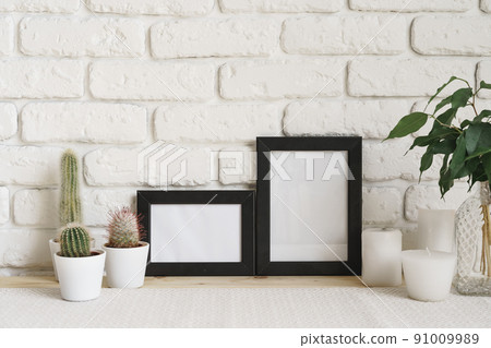 Square wooden photo frame and cactus plants on the table 91009989