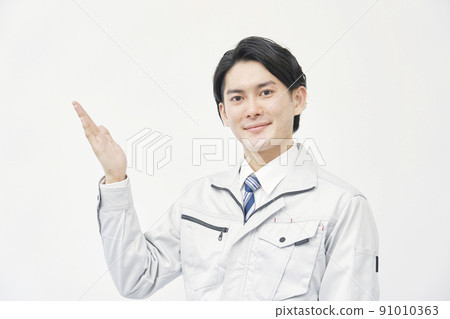 Worker pointing to the left side with the palm of his hand White background 91010363