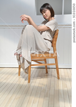 Young woman sitting on a chair Young woman sitting on a chair 91010850
