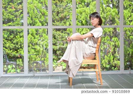 Young woman sitting on a chair Young woman sitting on a chair 91010869