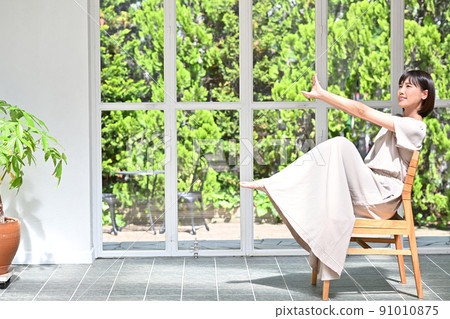 Young woman sitting on a chair 91010875