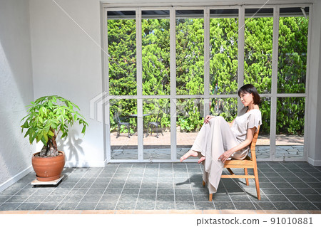 Young woman sitting on a chair Young woman sitting on a chair 91010881