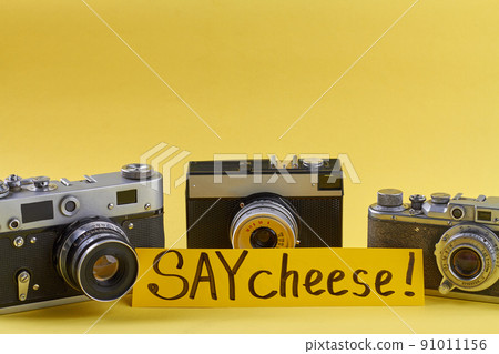 Three retro photo cameras isolated on yellow background. Three retro photo cameras isolated on yellow background. 91011156