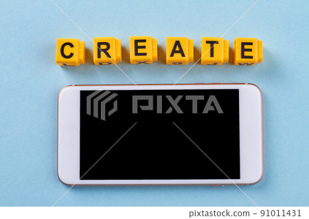 Smartphone with yellow cube lettes with word create. 91011431
