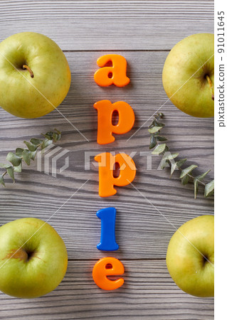 Apple word and green apples on grey table. 91011645