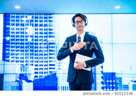 Businesswomen and businessmen wearing headsets talking in front of a huge display Businesswomen and businessmen wearing headsets talking in front of a huge display 91012336