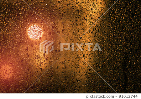 Water droplets on a window with city lights 91012744