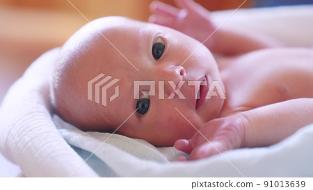 newborn. baby newborn a close-up lies looking at the camera in the hospital maternity hospital. lifestyle happy family baby dream concept. cute newborn baby wrapped in a blanket newborn. baby newborn a close-up lies looking at the camera in the hospital maternity hospital. lifestyle happy family baby dream concept. cute newborn baby wrapped in a blanket 91013639
