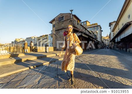 Woman walks on the Old bridge in Florence, Italy Woman walks on the Old bridge in Florence, Italy 91013955