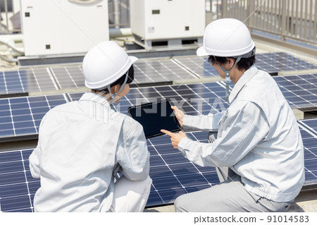 Businessmen and female workers checking solar panels 91014583
