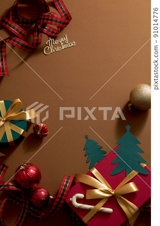 Brown background with colorful christmas ornament decoration , red gift box and ribbon with candy for holiday , top view with blank space for holiday advertising 91014776