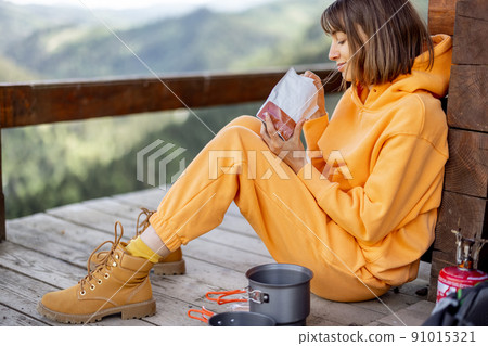 Woman eats while traveling in the mountains 91015321