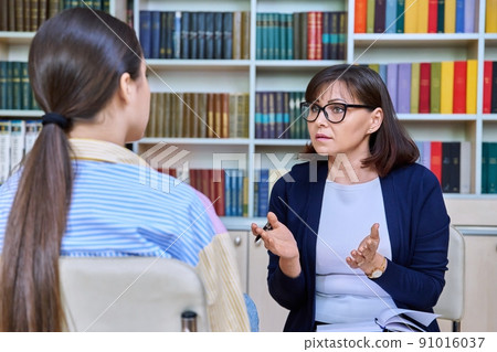 Female teacher talking to teenage student in the library Female teacher talking to teenage student in the library 91016037